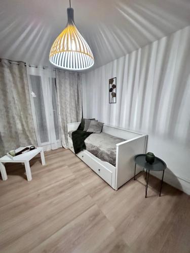 une chambre avec un lit, une table et un lustre dans l'établissement Appart à quelques pas de la mer, à La Grande Motte