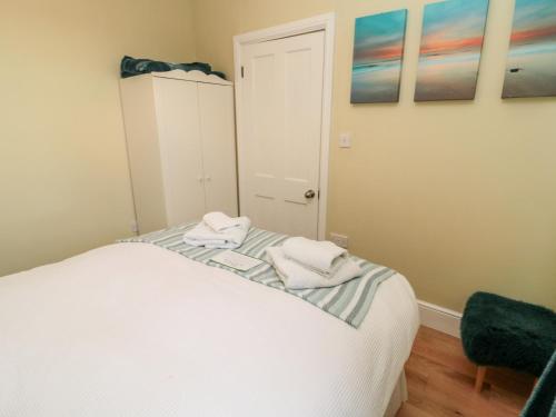 a bedroom with a bed with two towels on it at The Anchorage in Alnwick
