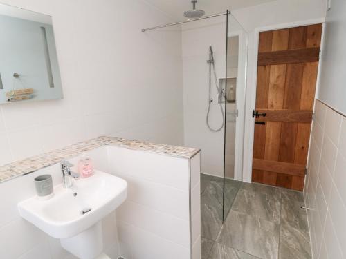 a white bathroom with a sink and a shower at The Anchorage in Alnwick