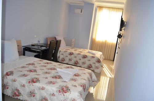 a room with a bed and a desk and a window at Hotel Okriba in Kutaisi