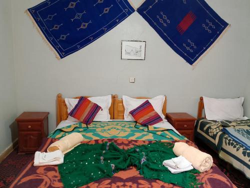 ein Schlafzimmer mit 2 Betten und Handtüchern darauf in der Unterkunft Auberge L'oasis in Merzouga