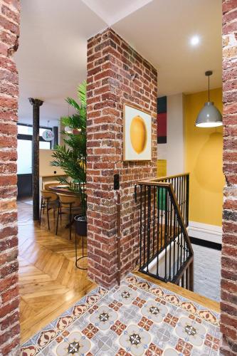 Cette chambre est dotée d'un mur en briques et d'un escalier. dans l'établissement Boutik Boheme - Triplex Monceau, à Paris