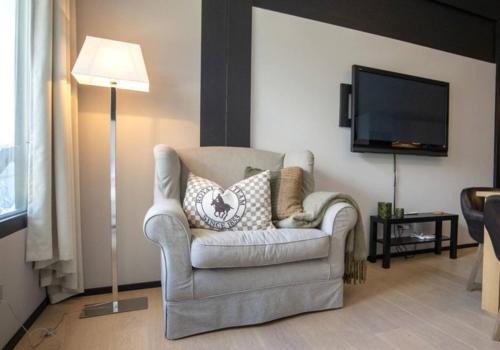 a living room with a chair and a flat screen tv at Lauchernalp Resort Residences in Wiler