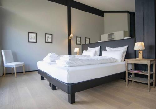 a bedroom with a large white bed and a chair at Lauchernalp Resort Residences in Wiler