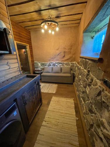 a living room with a couch and a stone wall at Salu Jahimaja in Soontaga