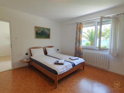 a bed in a room with a large window at Apartment with SeaView and Garden for 6 in Portorož