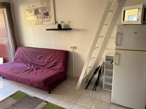 Cette petite chambre comprend un lit violet et un escalier. dans l'établissement Appartement Climatisé avec Parking à 500m de la Plage pour Vacances Familiales - FR-1-749-30, au Cap d'Agde