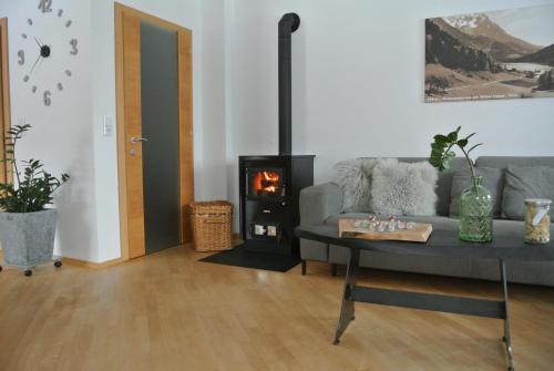 a living room with a couch and a wood stove at Appartement Seespitzhof in Scheffau am Wilden Kaiser