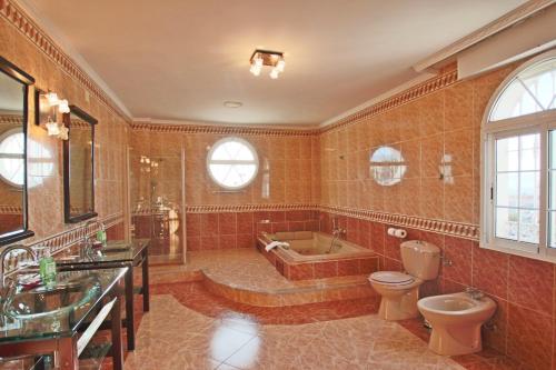 y baño con bañera, aseo y lavamanos. en TESS Villa Paradise, en Alhaurín de la Torre