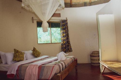 a bedroom with two beds and a window at Elephant View Lodge in Kasenyi
