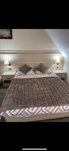 a large bed in a bedroom with two night stands at Apartmani Dušica Konaci Kopaonik in Kopaonik