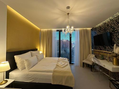 a bedroom with a white bed and a television at Villa Mala Praha Experience in the Center of Žilina in Žilina