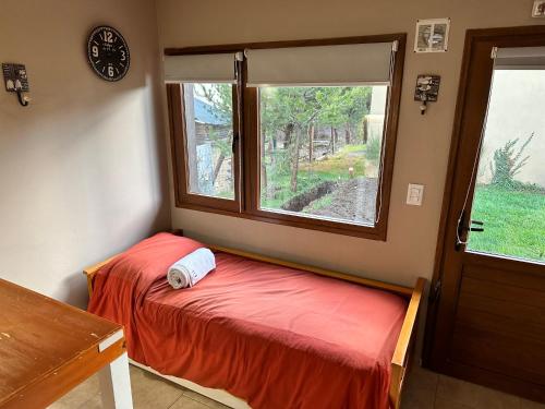 Cama pequeña en habitación con ventana en RETAMA en San Carlos de Bariloche