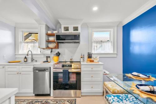 a kitchen with white cabinets and a blue wall at New2/2 Garden Apartment Historic in Savannah