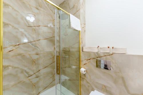 a bathroom with a shower with a glass door at Apartament Marmurowy Ku Morzu by Holidaysun in Sianozety