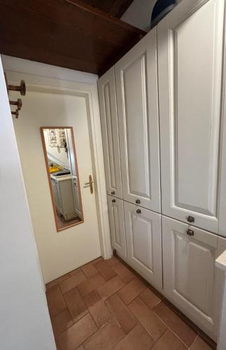 een keuken met witte kasten en een spiegel aan de muur bij LA SUITE in Spoleto