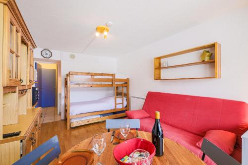 un salon avec un canapé rouge et une table dans l'établissement Les Aiguilles d'Arves - Vue montagne à au Corbier, à Villarembert