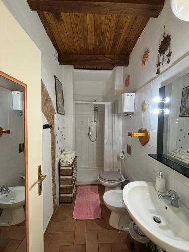 een badkamer met 2 wastafels, een toilet en een douche bij LA SUITE in Spoleto