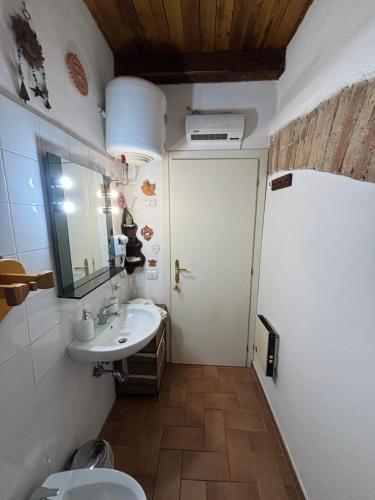 een badkamer met een wastafel, een toilet en een spiegel bij LA SUITE in Spoleto
