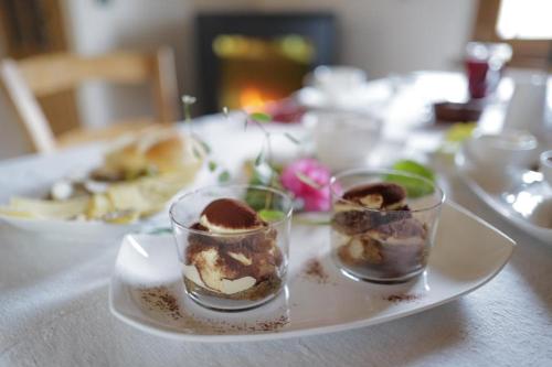 a white plate with three desserts on a table at Giardino Sospeso Agriturismo in Valdobbiadene