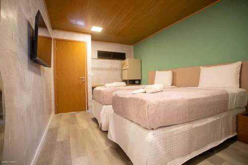 um quarto com duas camas num quarto com uma televisão em Bella Rosa Noronha em Fernando de Noronha