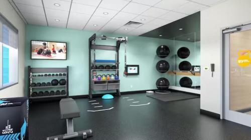 una sala de fitness con un gimnasio con muchos equipos en Tru By Hilton Lincoln East en Lincoln