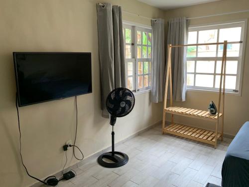 Zimmer mit einem Flachbild-TV und einem Ventilator. in der Unterkunft Recanto do Peixe Dourado in Casimiro de Abreu