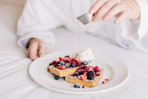 a person is serving a plate of food with fruit at InterContinental Toronto Centre by IHG in Toronto
