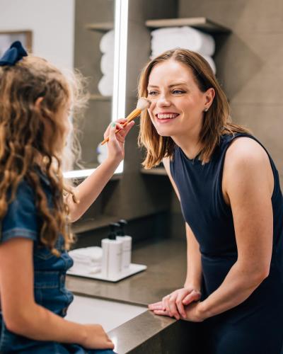 a woman brushing her teeth in front of a mirror at InterContinental Toronto Centre by IHG in Toronto