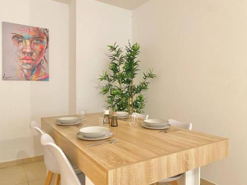 une table en bois avec des plaques et une plante sur celle-ci dans l'établissement Havre de Paix la joliette : Urban modern cosy chic, à Marseille