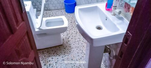 een badkamer met een wastafel en een toilet bij Studio at Kisimani Heights Apartment. in Mombasa