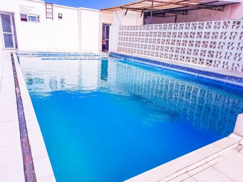 een zwembad met blauw water naast een gebouw bij Studio at Kisimani Heights Apartment. in Mombasa