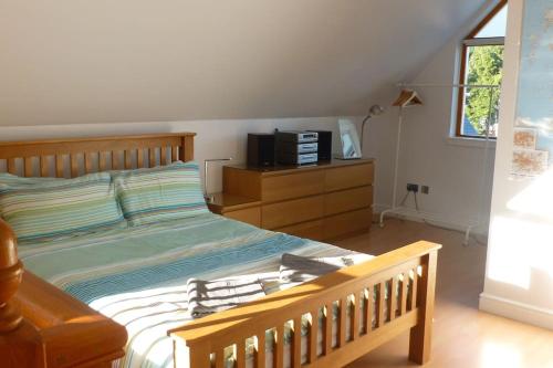 a bedroom with a bed and a tv on a dresser at The Bothy, Nethy Bridge in Nethy Bridge