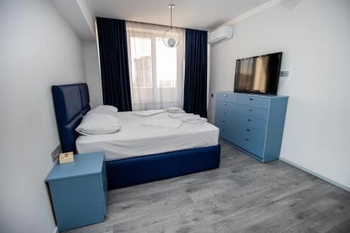 a bedroom with a bed with a blue dresser and a tv at Hotel Tigran Mets in Yerevan