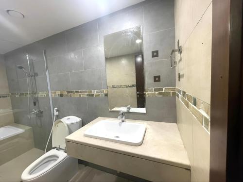 La salle de bains est pourvue d'un lavabo, de toilettes et d'un miroir. dans l'établissement Heart of Abu Dhabi - Elite Community, à Abu Dhabi