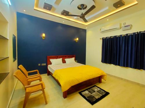 a bedroom with a bed and a chair in it at Little Dream Homestay Hampi in Hampi