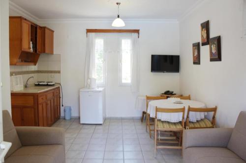 a living room with a table and a kitchen at Toloman Bitezpark Apartments in Bodrum City