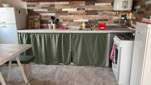 玛尔德科博Casa a 50 mts de la playa的厨房里有一张铺着绿色桌布的桌子