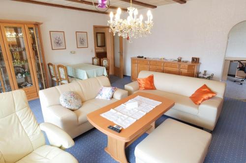 ein Wohnzimmer mit weißen Möbeln und einem Kronleuchter in der Unterkunft Ferienhaus Residenz Wismar - ABC430 in Wismar