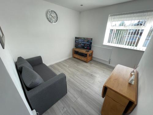 uma sala de estar com um sofá e uma mesa em Lovely 1 bedroom flat. Parking & Garage. Sky TV & Broadband em Colchester