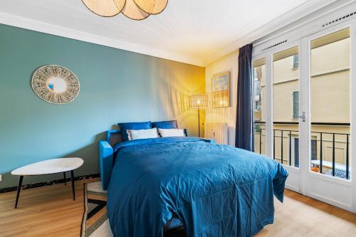 une chambre avec un lit bleu et un balcon dans l'établissement NICE RENTING - PHILIBERT - Elegant Spacious Quiet Near the Port Free Parking, à Nice