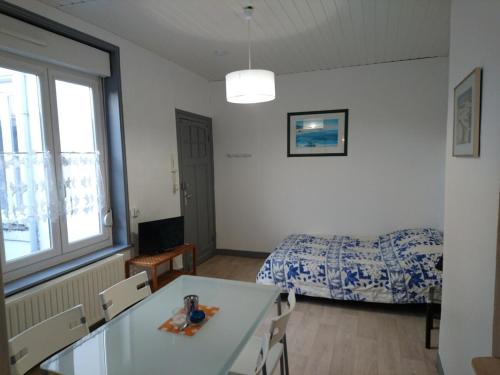 une chambre avec un lit et une table dans une pièce dans l'établissement Studio N°4 Boston Conciergerie Leroy, à Boulogne-sur-Mer