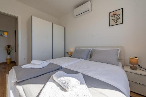 a bedroom with a large bed with two towels on it at Dolphin view with a pool by the beach in Mandre