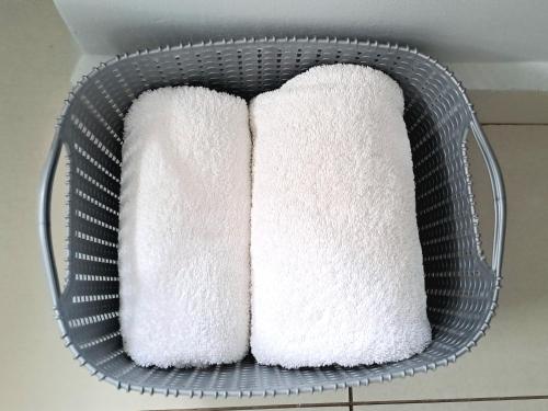 a basket filled with white towels in a bathroom at Cozy Sparrow Hideaway in Sandton