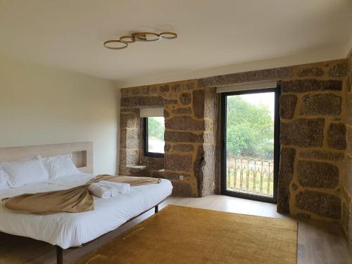 una camera con letto e muro di mattoni di Botica House a Póvoa de Lanhoso