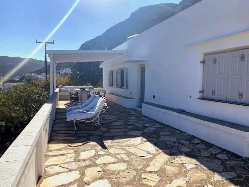 a balcony of a white house with a table and chairs at Renovated traditional family house in Sifnos in Kamarai