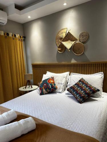 a bedroom with a bed with white sheets and pillows at Pousada dos Sonhos - MP in Miguel Pereira