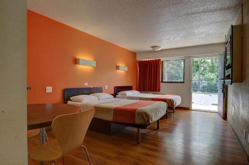 Habitación de hotel con 2 camas y mesa en Motel 6-Kansas City, MO en Kansas City