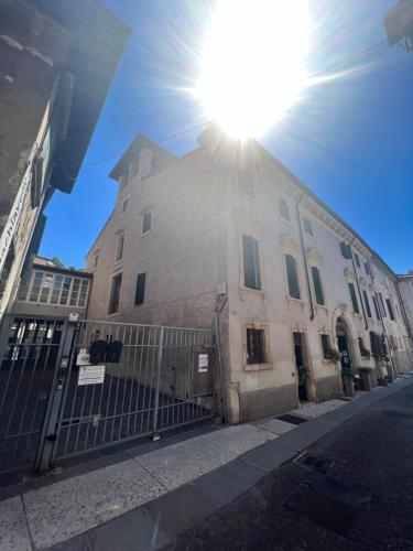 a building on a street with the sun shining on it at Pietra di Verona Residenza in Verona