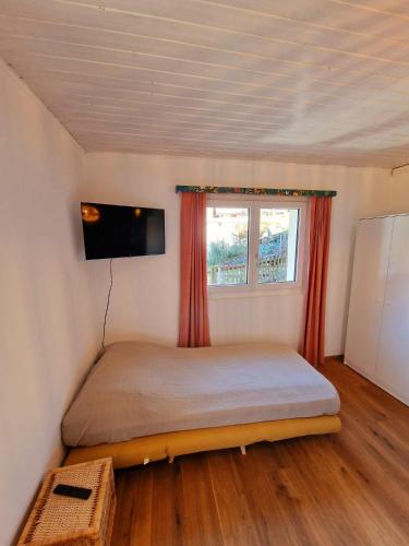 a bedroom with a bed and a tv on the wall at Kunstplanet im Herzen der Alpen am Planetenweg in Visp